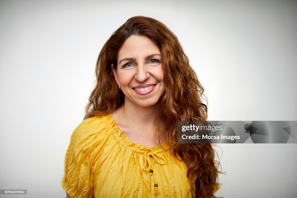 Smiling mid adult woman with long wavy hair