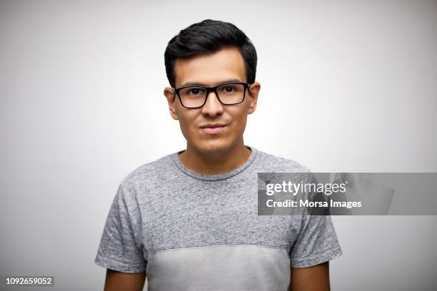 portrait of young man wearing eyeglasses - handsome mexican men stock-fotos und bilder