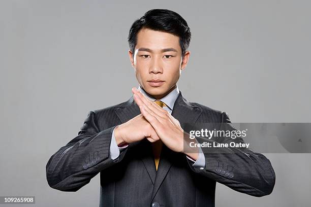 businessman using hands to greet on grey background - kung fu pose stock pictures, royalty-free photos & images