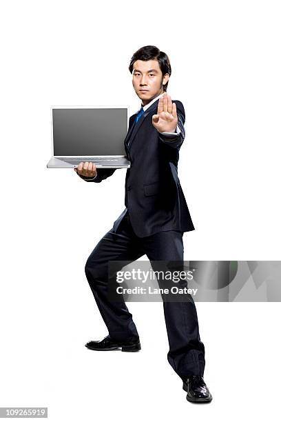businessman in fighting stance holding laptop - kung fu pose stock pictures, royalty-free photos & images