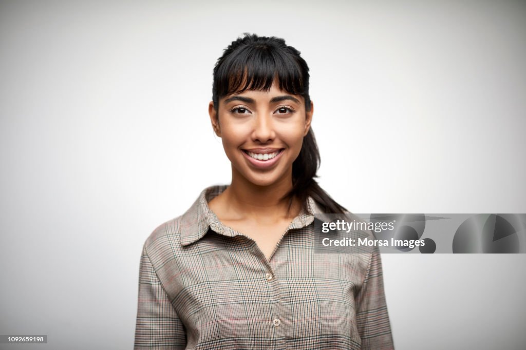 Beautiful young woman smiling on white background