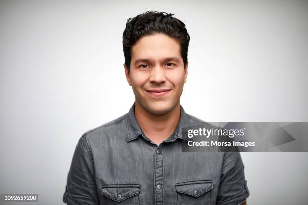 close-up portrait of smiling young man - gray shirt stock pictures, royalty-free photos & images