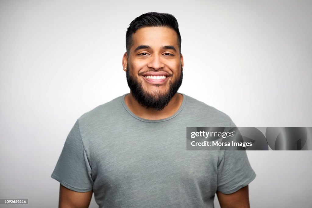 Young man smiling against white background