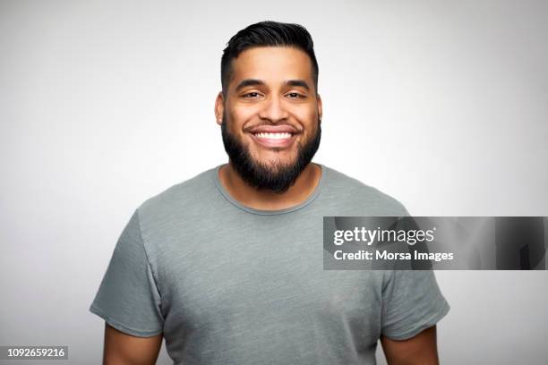 young man smiling against white background - gray shirt bildbanksfoton och bilder