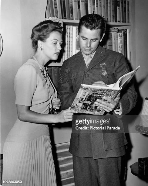 American actors Glenn Ford and Eleanor Powell reading 'You Have Seen Their Faces', a photography book by Margaret Bourke-White and Erskine Caldwell,...