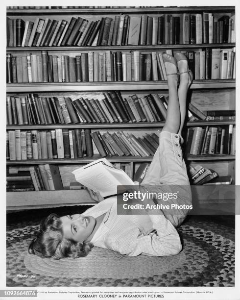 American singer and actress Rosemary Clooney reading in her home in Brentwood, Los Angeles, 1952. She is in the middle of filming 'The Stars are...