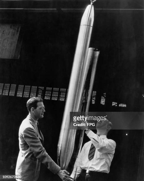 The first Westinghouse Time Capsule, a 7.5 foot capsule with an inner shell of heat-resistant glass, is inspected by two experts before being shipped...