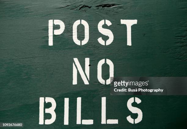 "post no bills" sign on wooden fence around construction site in the streets of manhattan, new york city - nyc building sun ストックフォトと画像