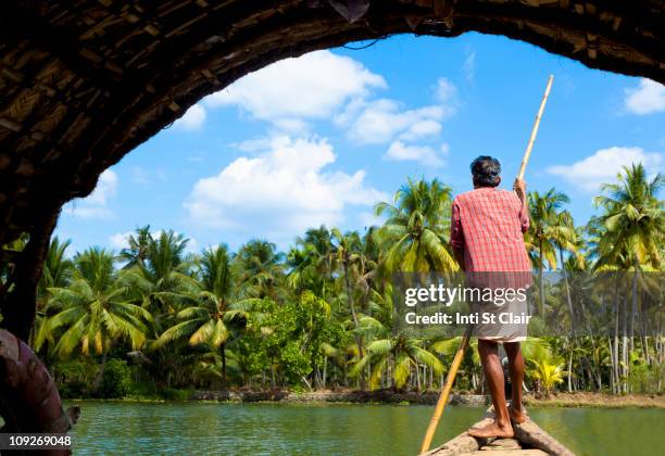 man standing in boat on tranquil forest river - kochi india stock pictures, royalty-free photos & images