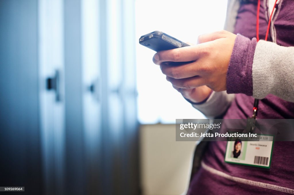 Japanese businesswoman using cell phone in office technology room