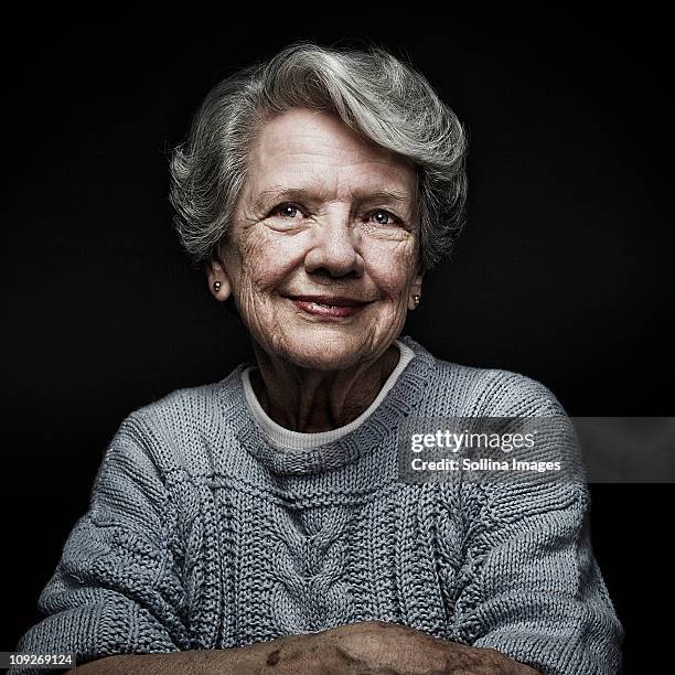 smiling, aging caucasian woman - frau schwarzer hintergrund stock-fotos und bilder