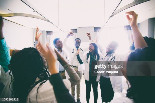 group of african medical students celebrating and laughing spontaneously together - africa hospital stock pictures, royalty-free photos & images