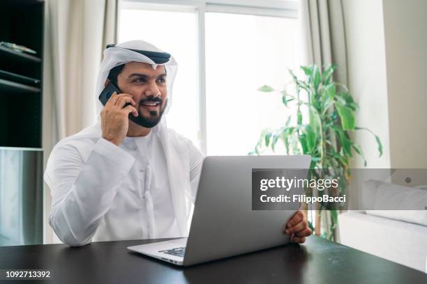 arabischer mann arbeitet mit laptop - emirati guy using laptop stock-fotos und bilder