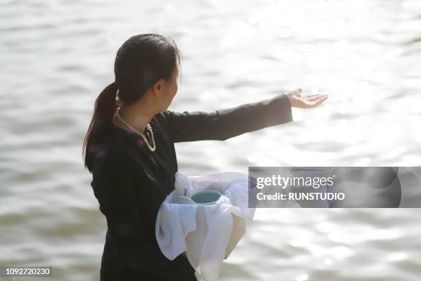 woman with urn spreading ashes - funeral parlor stock pictures, royalty-free photos & images