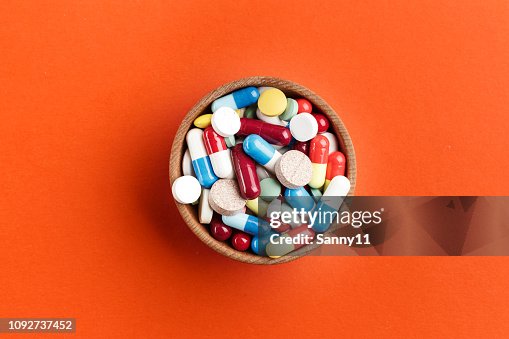 Different colored pills in a plate on a bright background. Different colored pills in a plate on a bright background.