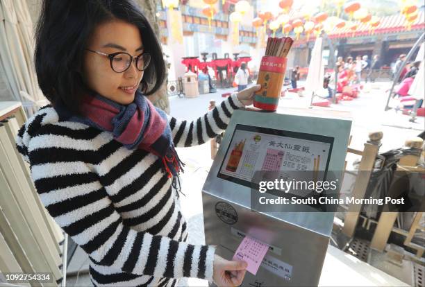 Model Cha Cha Chan demonstrates a machine that can print out divination of fortune stick at Wong Tai Sin Temple in Wong Tai Sin. 25JAN17 SCMP /...