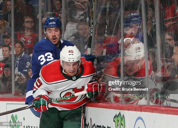 Sami Vatanen of the New Jersey Devils checks Frederik Gauthier of the Toronto Maple Leafs at the Prudential Center on January 10, 2019 in Newark, New...