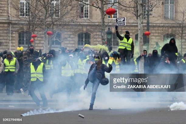 Protesters throw back tear gas canisters thrown by police at Place de la Republique on February 2, 2019 in Paris, on the sidelines of a march called...