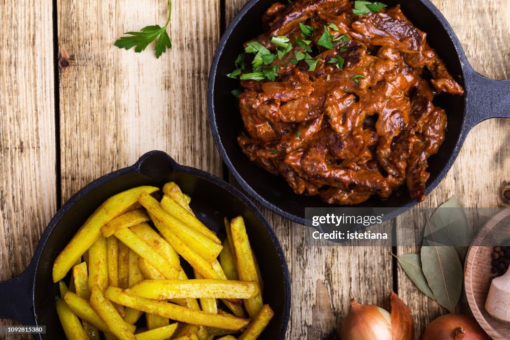 Beef Stroganoff served with fried potato in cast iron skillet