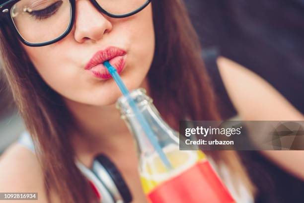 stedelijke meisje flessen frisdrank drinken - fizzy drink stockfoto's en -beelden