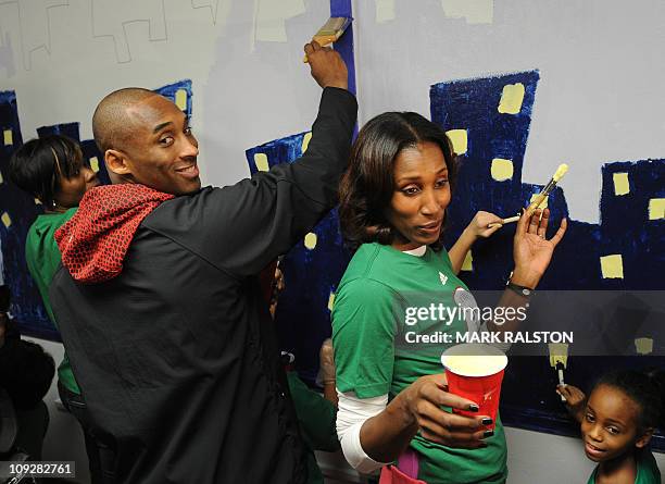 Star Kobe Bryant from the Los Angeles Lakers, is helped by Lisa Leslie from the WNBA as they participate in the "City Year School Refurbishment...