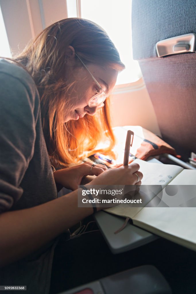 Millennial woman travelling alone in plane.