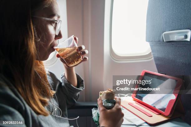 millennial woman travelling alone in plane. - flight food stock pictures, royalty-free photos & images