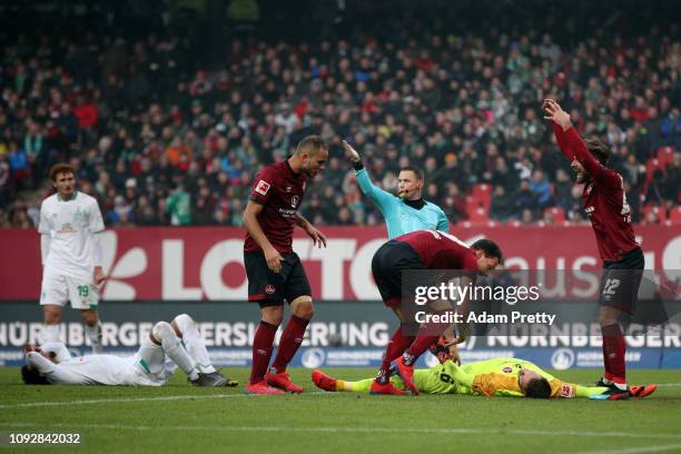 Nuernberg players react after Christian Mathenia of Nuernberg clashes heads with Theodor Gebre Selassie of Werder Bremen during the Bundesliga match...