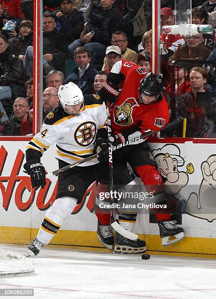 Peter Regin of the Ottawa Senators battles for the loose puck with Dennis Seidenberg of the Boston Bruins at Scotiabank Place on February 18, 2011 in...