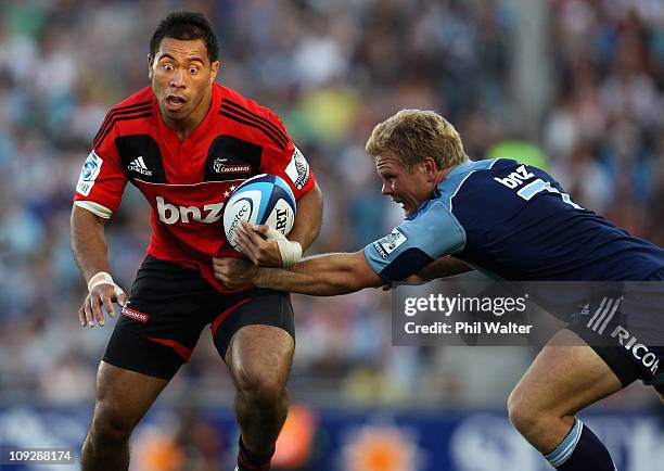 Tu Umaga-Marshall of the Crusaders is tackled by Daniel Braid of the Blues during the round one Super Rugby match between the Blues and the Crusaders...