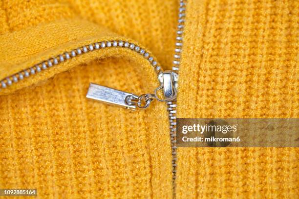 close-up of zipper on yellow sweater - zip fotografías e imágenes de stock