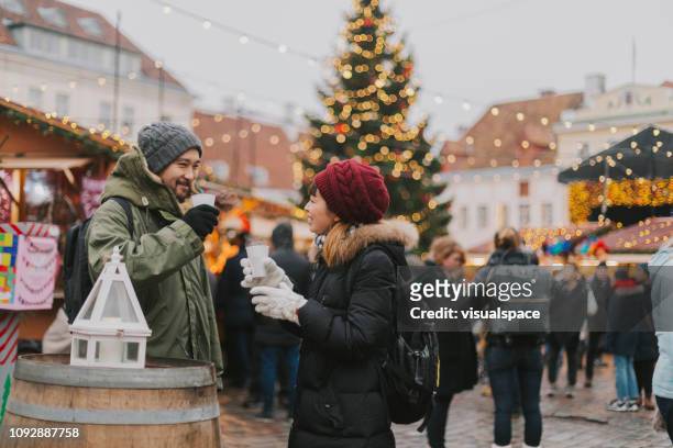 couple drinks mulled wine at christmas market - tallinn stock pictures, royalty-free photos & images