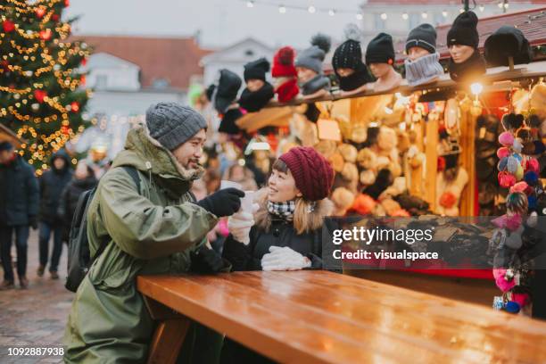 japanse paar drinken glühwein op kerstmarkt in tallinn - hot toddy stockfoto's en -beelden
