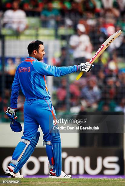 Virender Sehwag of India raises his bat on reaching his century during the opening game of the ICC Cricket World Cup between Bangladesh and India at...