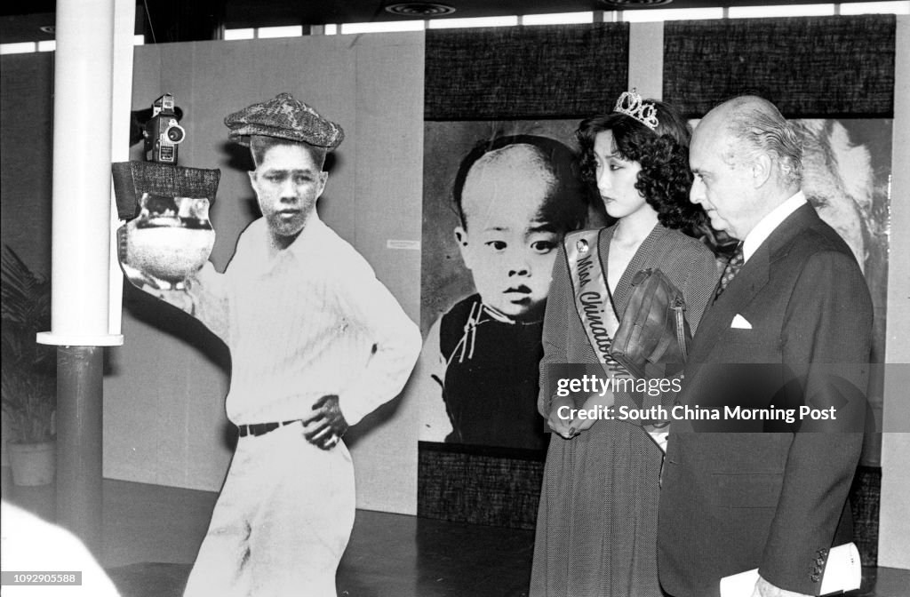 The Chairman of the Urban Council, Arnaldo de Oliveira Sales (right), and Miss Tina Lau Tin-lan, Miss Chinatown (Vancouver), appraising a life-size picture of famous cinematographer, James Wong Howe, at the opening ceremony of the second International Fil