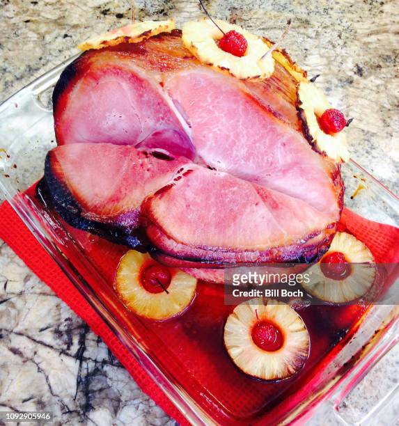 honey-baked ham pre-sliced with pineapple rings and cherries in a baking - honey ham stock pictures, royalty-free photos & images