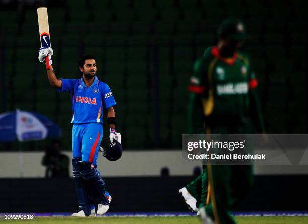 Virat Kohli of India raises his bat on reaching his century during the opening game of the ICC Cricket World Cup between Bangladesh and India at the...