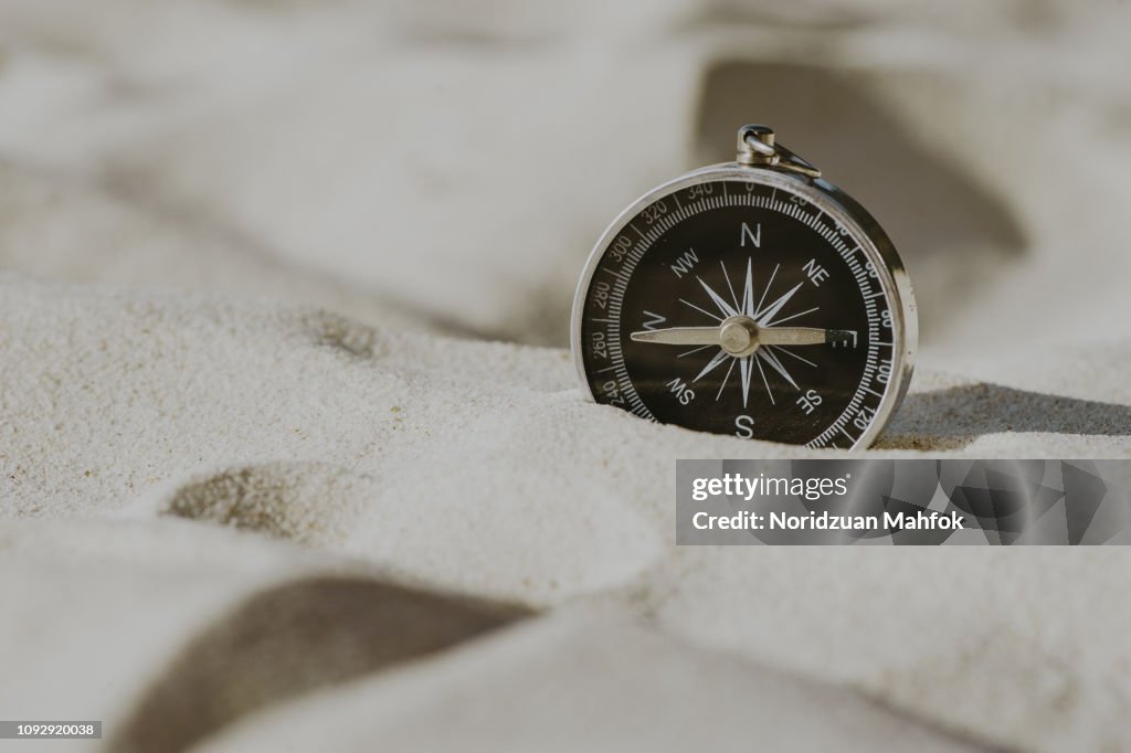 Compass on the sea sand at the beach