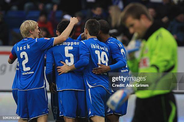 Marvin Compper of Hoffenheim celebrates his team's first goal with team mates as goalkeeper Michael Rensing of Koeln reacts during the Bundesliga...