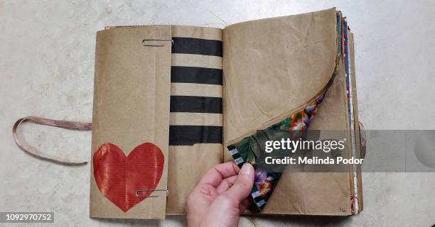 hand opening a handmade "junk journal" - reliures photos et images de collection