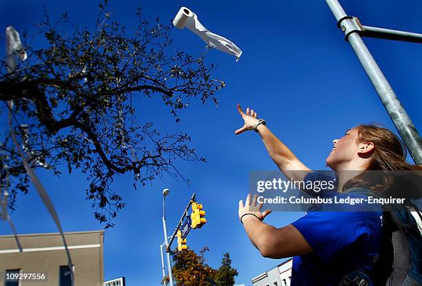 Grace Langhout, an Auburn university freshman from Huntsville, Alabama, tosses a roll of toilet paper up into one of the two oak trees at Toomer's...