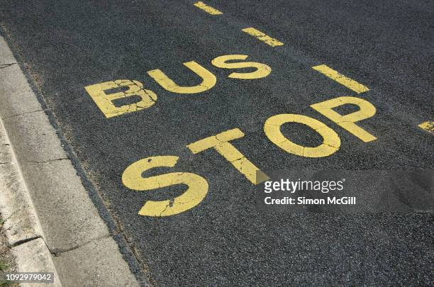 bus stop zone painted on a road - kerb stock pictures, royalty-free photos & images