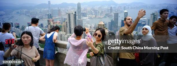 Tourists using their cellphones to take the selfie at the Peak, The Mid-Levels. Typhoon Hato expects coming tonight. SCMP/Robert Ng