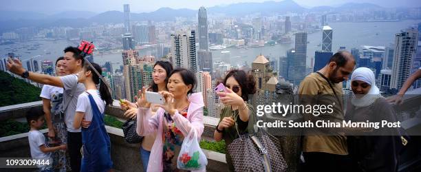 Tourists using their cellphones to take the selfie at the Peak, The Mid-Levels. Typhoon Hato expects coming tonight. SCMP/Robert Ng