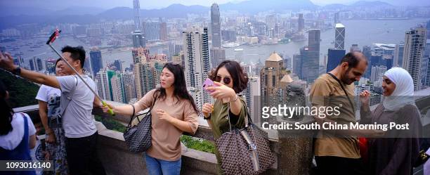 Tourists using their cellphones to take the selfie at the Peak, Mid-Level. Typhoon is expected coming tonight. 22AUG17 SCMP/Robert Ng