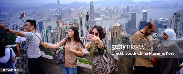 Tourists using their cellphones to take the selfie at the Peak, Mid-Level. Typhoon is expected coming tonight. 22AUG17 SCMP/Robert Ng