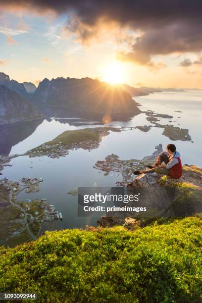 traveller enjoy summer view of lofoten islands in norway with sunset scenic - reine stock pictures, royalty-free photos & images