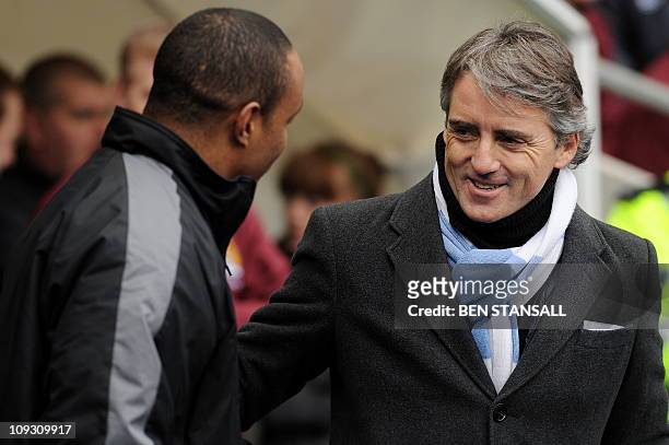 Manchester City's Italian manager Roberto Mancini speaks with Notts County's English manager Paul Ince ahead of the FA Cup fourth round replay...