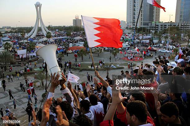 Anti-government protesters wave flags and demonstrate at the Pearl roundabout on February 20, 2011 in Manama, Bahrain. Protesters filled the square...