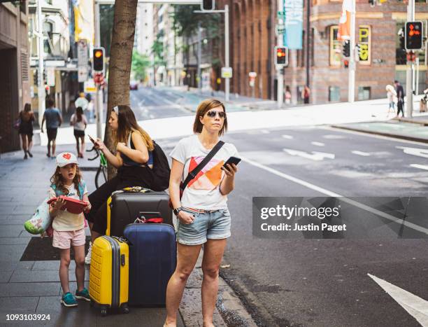 mother and daughters waiting for taxi - australia taxi stock pictures, royalty-free photos & images